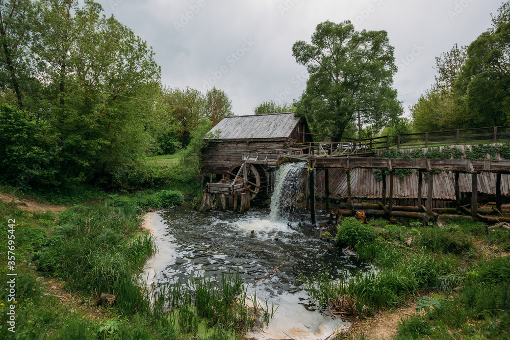 Old wooden log watermill in Russian village