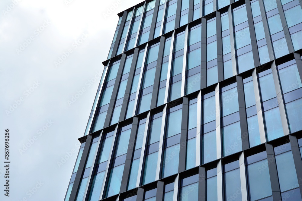 Facade texture of a glass mirrored office building. Fragment of the facade. Modern architecture of the office building. Facade texture of a glass mirrored office building. Fragment of the facade. Modern architecture of the office building.