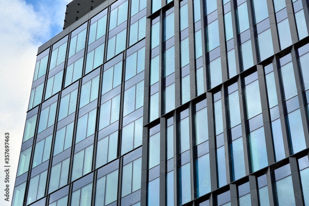 Facade texture of a glass mirrored office building. Fragment of the facade. Modern architecture of the office building. Facade texture of a glass mirrored office building. Fragment of the facade. Modern architecture of the office building.