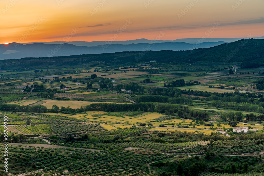 Mountainous aerial landscape with wheat crop fields at sunset