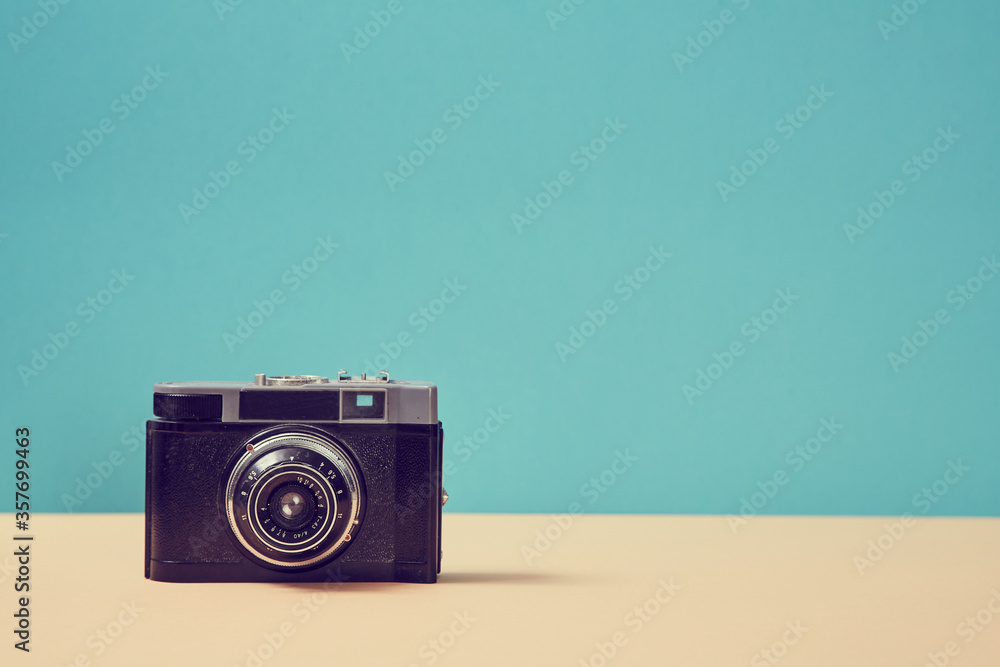 Vintage camera on blue background. Retro device for recording visual images. Travelling. Blogging. Memories concept