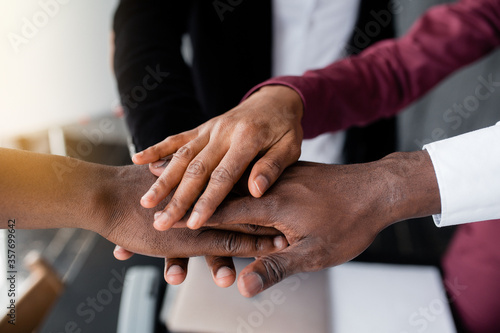 The hands of black people in the center hold each other to unite against racism in large countries. Black lives matter