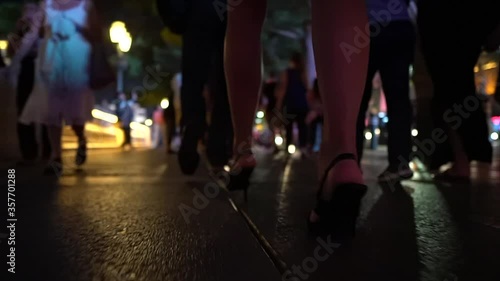 Young woman is walking in her high heels down the night streets - Close up of her sexy nice legs