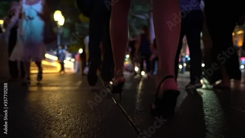Young woman is walking in her high heels down the night streets - Close up of her sexy nice legs photo