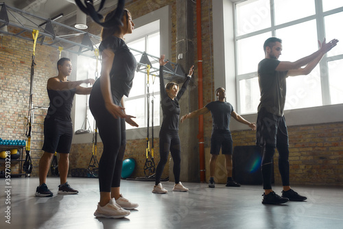 Bodies of stamina and strength. Full-length shot of diverse athletic men and women working out together in industrial gym. Group, training concept