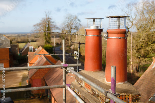 Clay chimney pot with cowl on a roof in UK