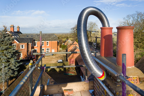 Obraz na plátně Installing flue liner in a chimney, UK