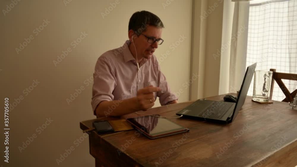 time lapse of middle aged man working from home participating in a video conference with his laptop