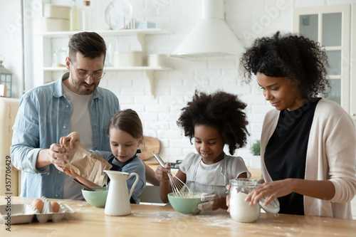 Foto Multi racial full family cooking pastries gathered together in kitchen mixing products fresh ingredients eggs flour and milk make dough preparing holiday cake