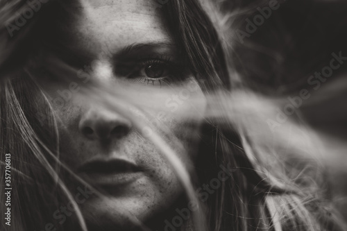 Fototapeta moody portrait of young woman and wind through hair
