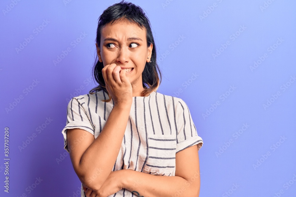 Young woman wearing casual clothes looking stressed and nervous with hands on mouth biting nails. anxiety problem. Young woman wearing casual clothes looking stressed and nervous with hands on mouth biting nails. anxiety problem.