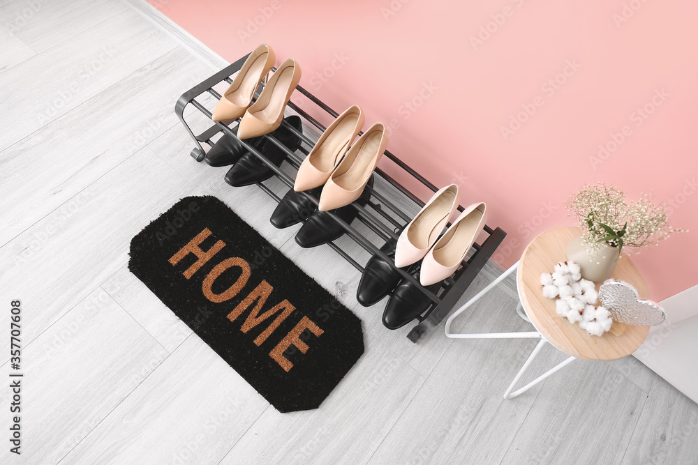 Door mat and stand with shoes in hallway Door mat and stand with shoes in hallway