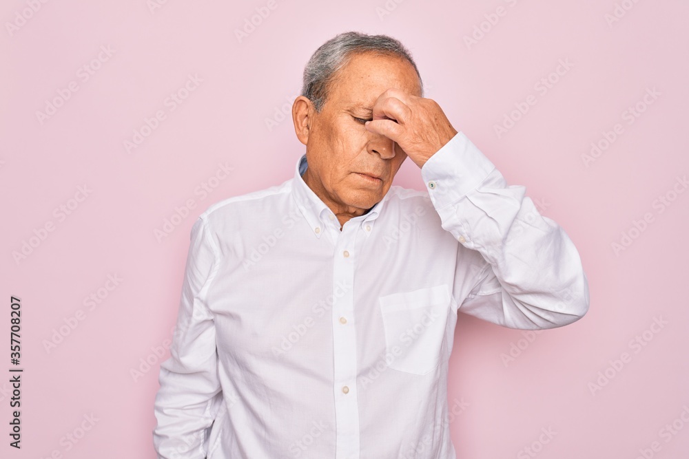 Obraz premium Senior handsome grey-haired man wearing elegant shirt over isolated pink background tired rubbing nose and eyes feeling fatigue and headache. Stress and frustration concept.