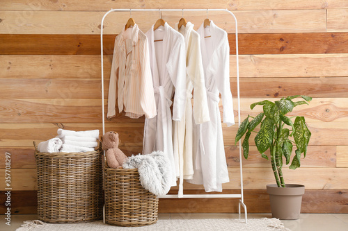 Baskets with laundry and clothes hanger near wooden wall in room