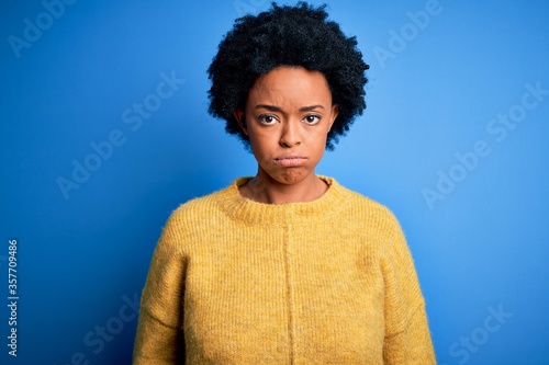 Young beautiful African American afro woman with curly hair wearing yellow casual sweater depressed and worry for distress, crying angry and afraid. Sad expression. © Krakenimages.com