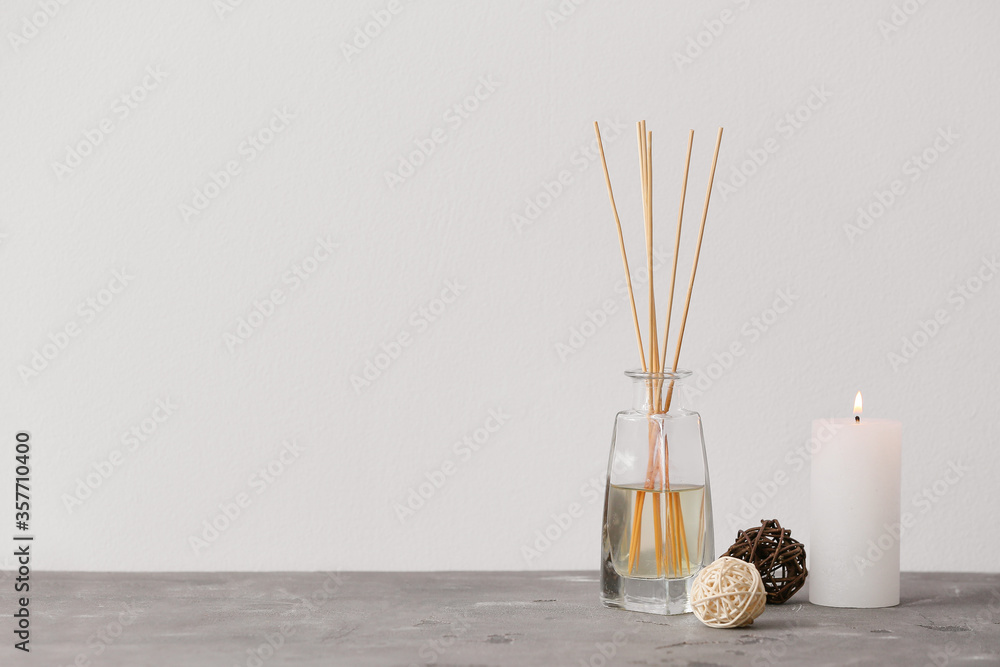 Reed diffuser and candle on table in room