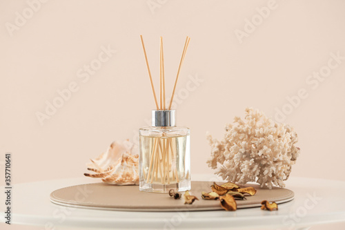 Reed diffuser and sea shells on table in room photo
