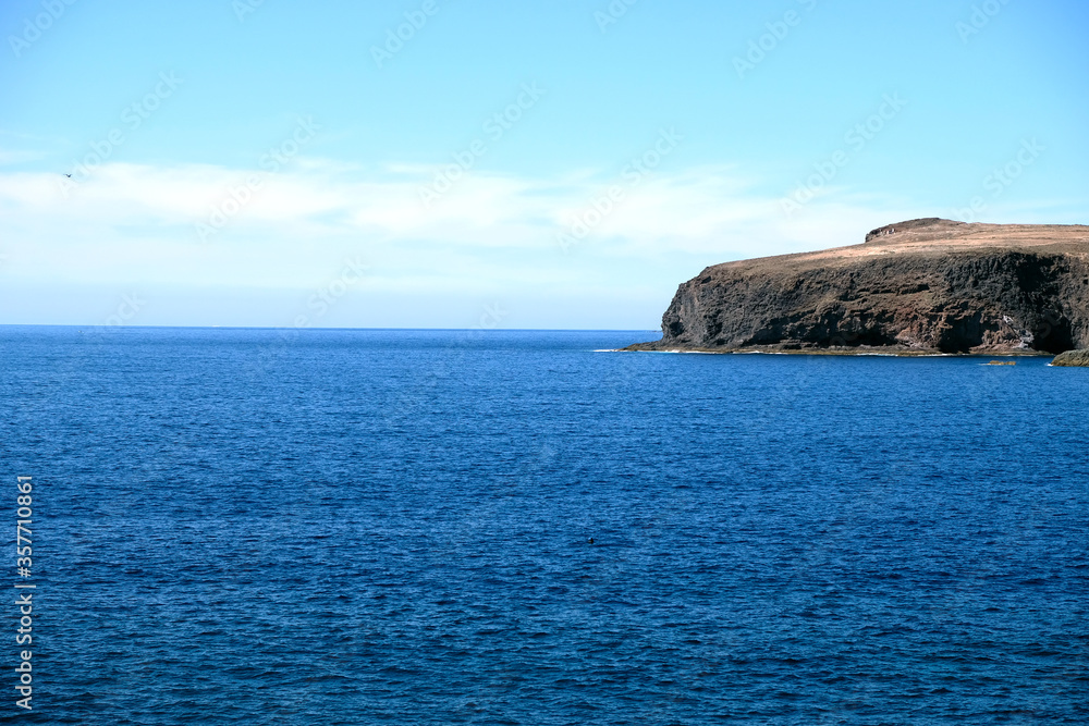 Rocky headland and ocean. Pronounced cape, Gran Canaria, Canary Islands, Spain, Africa. Large empty copy space.