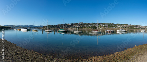 Panoramic View of yachts and boats reflecting in the water docked in Porirua near Wellington New Zealand on a calm sunny day photo