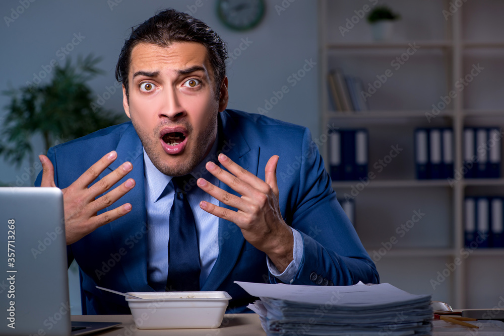 Hungry employee working late in the office Hungry employee working late in the office