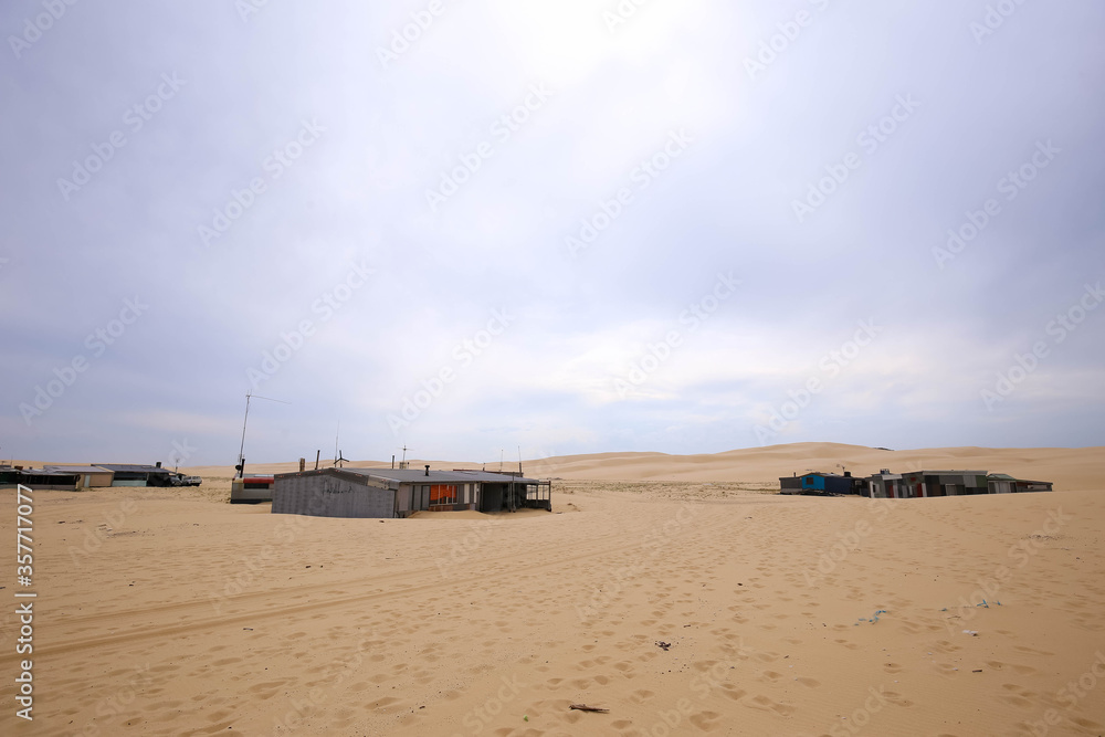 Tin fisherman's huts on wide sandy beach Tin fisherman's huts on wide sandy beach