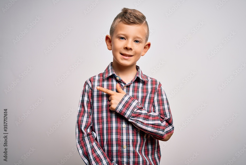 Young little caucasian kid with blue eyes wearing elegant shirt standing over isolated background cheerful with a smile on face pointing with hand and finger up to the side Young little caucasian kid with blue eyes wearing elegant shirt standing over isolated background cheerful with a smile on face pointing with hand and finger up to the side