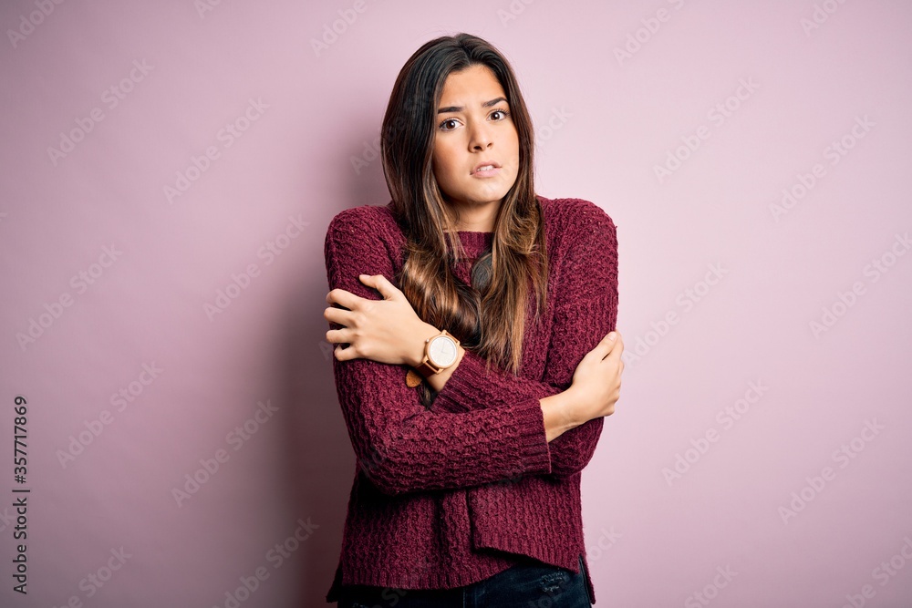 Young beautiful girl wearing casual sweater over isolated pink background shaking and freezing for winter cold with sad and shock expression on face Young beautiful girl wearing casual sweater over isolated pink background shaking and freezing for winter cold with sad and shock expression on face
