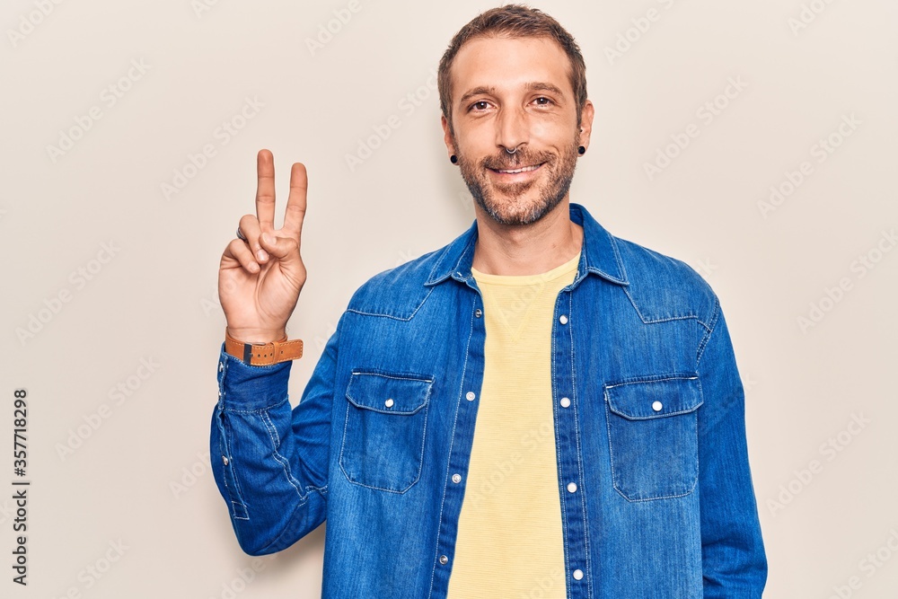 Young handsome man wearing casual clothes smiling with happy face winking at the camera doing victory sign. number two. Young handsome man wearing casual clothes smiling with happy face winking at the camera doing victory sign. number two.