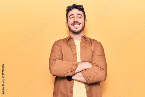 Young hispanic man wearing casual clothes happy face smiling with crossed arms looking at the camera. positive person. © Krakenimages.com