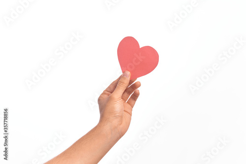 Hand of caucasian young man holding red paper heart shape over isolated white background