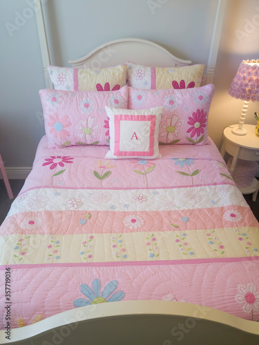 Bedroom interior with colorful printed feminine beddings pn the single bed