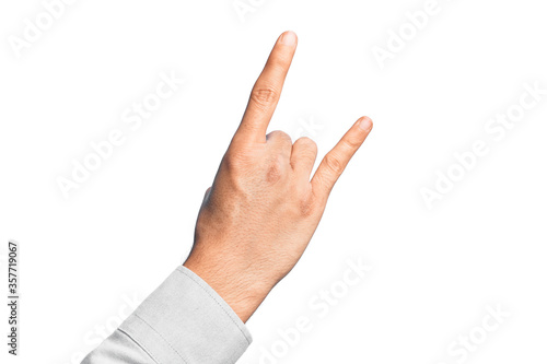 Hand of caucasian young man showing fingers over isolated white background gesturing rock and roll symbol, showing obscene horns gesture