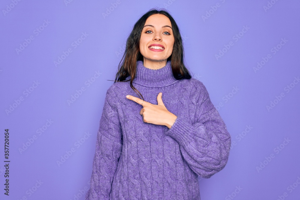 Young beautiful woman wearing casual turtleneck sweater standing over purple background cheerful with a smile on face pointing with hand and finger up to the side with happy and natural expression Young beautiful woman wearing casual turtleneck sweater standing over purple background cheerful with a smile on face pointing with hand and finger up to the side with happy and natural expression