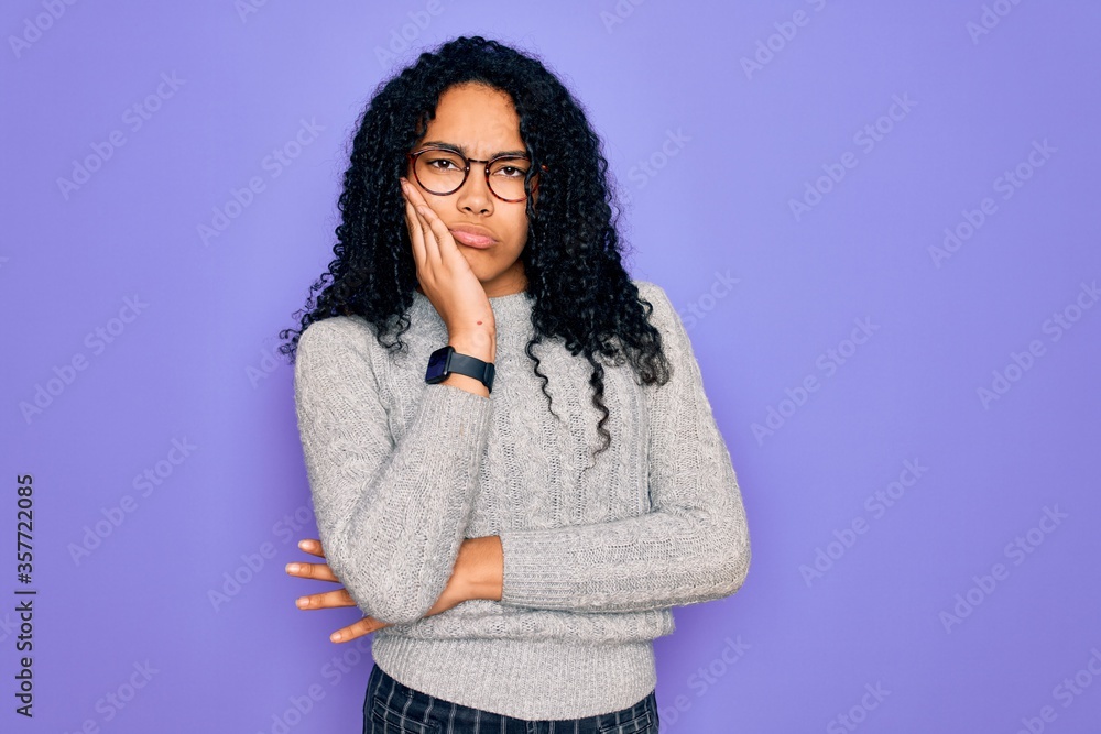 Young african american woman wearing casual sweater and glasses over purple background thinking looking tired and bored with depression problems with crossed arms. Young african american woman wearing casual sweater and glasses over purple background thinking looking tired and bored with depression problems with crossed arms.