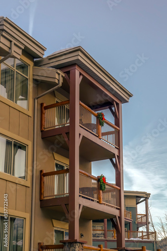 Residential building balconies with festive Christmas wreath against blue sky