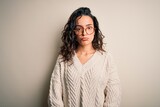 Beautiful woman with curly hair wearing casual sweater and glasses over white background depressed and worry for distress, crying angry and afraid. Sad expression.