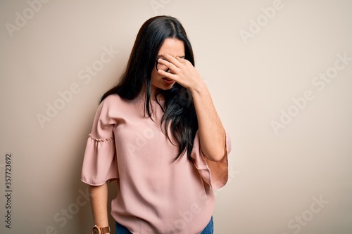 Young brunette elegant woman wearing glasses over isolated background tired rubbing nose and eyes feeling fatigue and headache. Stress and frustration concept.