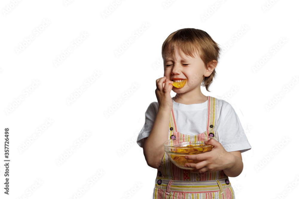 Cute little girl eating one piece of chips in her hand with plate of potatoe Cute little girl eating one piece of chips in her hand with plate of potatoe