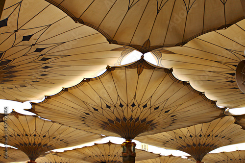Canopies in Nabawi Mosque in Medina, Saudi Arabia.  Muslim pilgrims visiting the beautiful Nabawi Mosque, the Prophet mosque which has great architecture during hajj and umrah season. photo