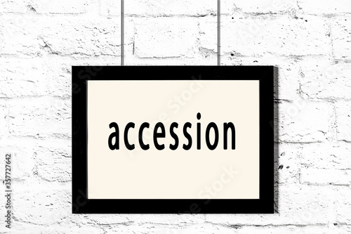 Canvas Print Black frame hanging on white brick wall with inscription accession