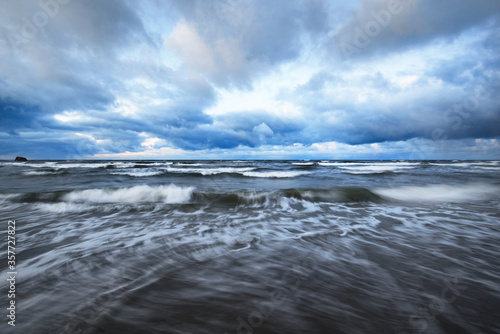Fototapeta Naklejka Na Ścianę i Meble -  Storm clouds above the Baltic sea in winter, long exposure. Dramatic sunset sky, waves and water splashes. Dark seascape. Germany