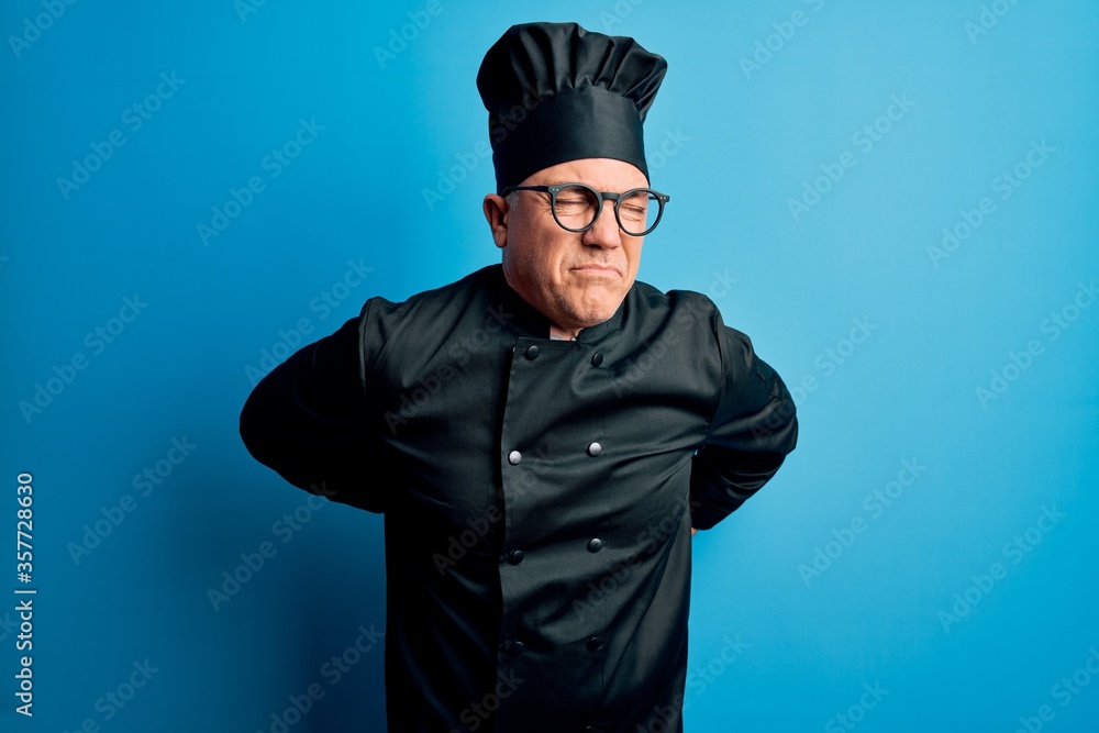Middle age handsome grey-haired chef man wearing cooker uniform and hat Suffering of backache, touching back with hand, muscular pain Middle age handsome grey-haired chef man wearing cooker uniform and hat Suffering of backache, touching back with hand, muscular pain