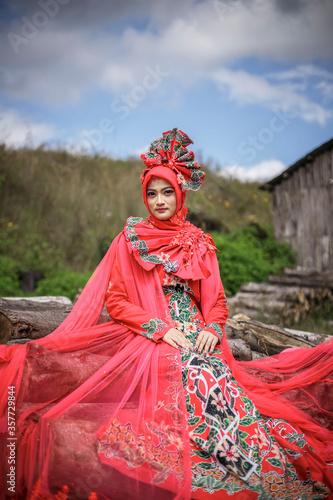 Young Asian women wearing Indonesian traditional costumes, Bondowoso Batik in red. The traditional female outfits originated from Indonesia.