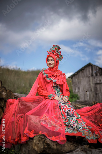 Young Asian women wearing Indonesian traditional costumes, Bondowoso Batik in red. The traditional female outfits originated from Indonesia.