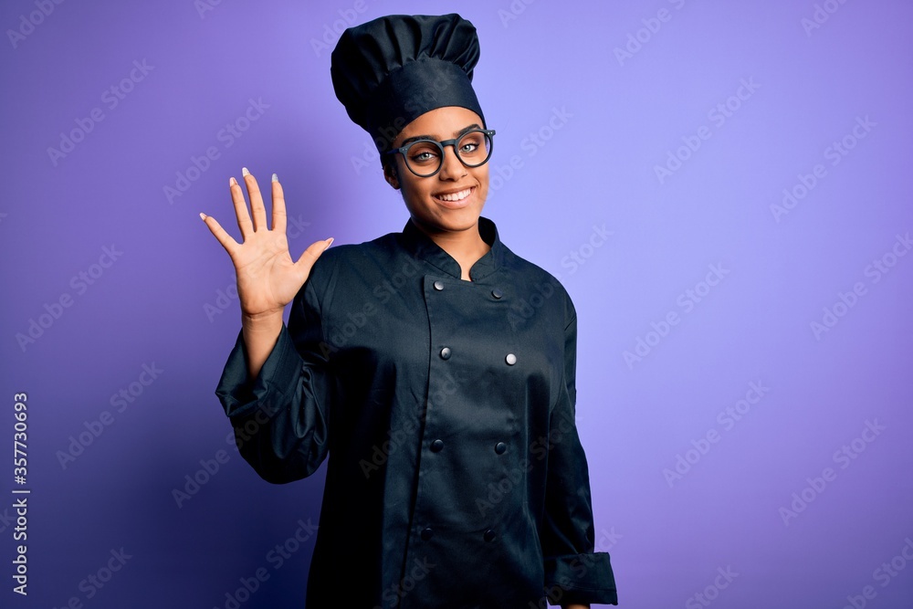 Young african american chef girl wearing cooker uniform and hat over purple background showing and pointing up with fingers number five while smiling confident and happy. Young african american chef girl wearing cooker uniform and hat over purple background showing and pointing up with fingers number five while smiling confident and happy.