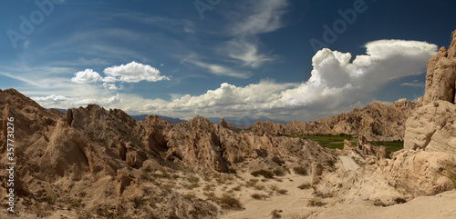 Panorama view of the desert mountains, sandstone and rocky formations under a blue sky. 