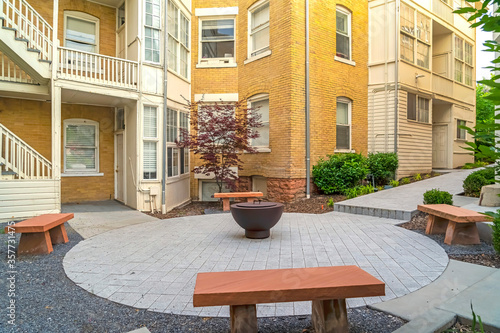 Stone benches around fire pit outside of a residential building complex
