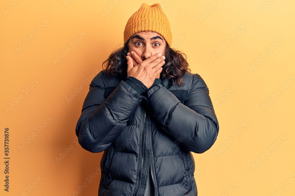 Young arab man wearing casual winter clothes shocked covering mouth with hands for mistake. secret concept. Young arab man wearing casual winter clothes shocked covering mouth with hands for mistake. secret concept.