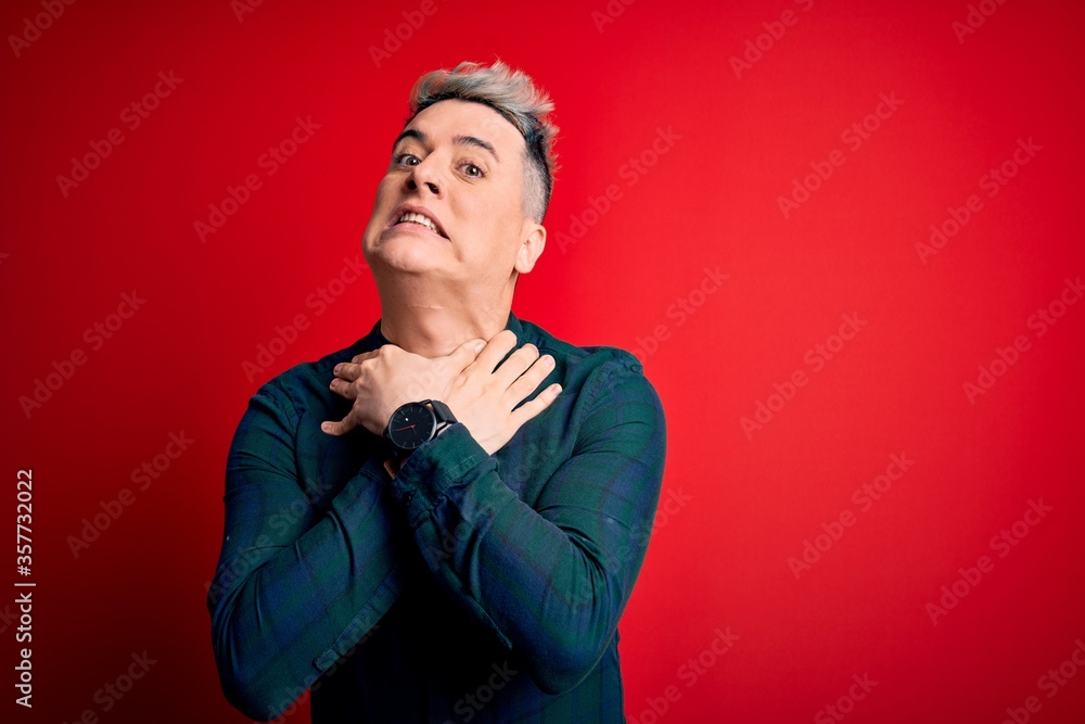 Young handsome modern man wearing elegant green shirt over red isolated background shouting suffocate because painful strangle. Health problem. Asphyxiate and suicide concept. Young handsome modern man wearing elegant green shirt over red isolated background shouting suffocate because painful strangle. Health problem. Asphyxiate and suicide concept.