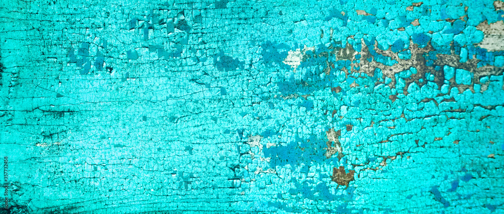 Old crackled teal turquoise painted wood surface. Vintage wooden wall or floor with cracked paint.